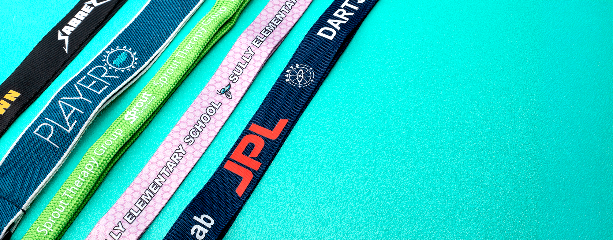 Various custom lanyard types including Playero, Sully Elementary School, JPL, and Dart designs on teal background